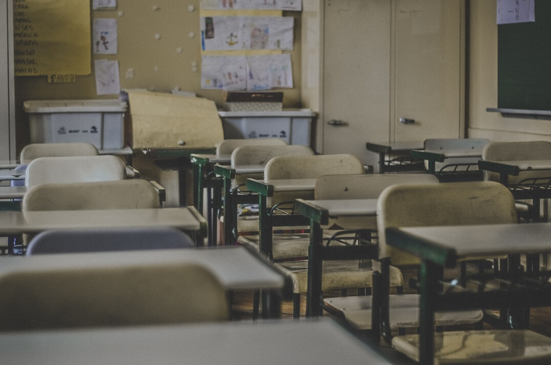 Students in a classroom listening to a teacher